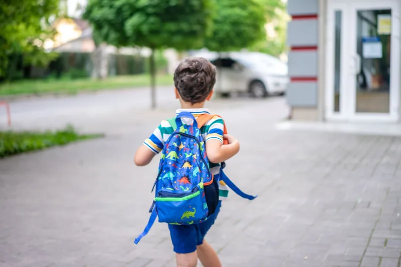 Child with a backpack heading back to school for the new school year