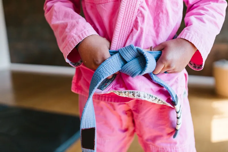A confident young child in a martial arts uniform, showing how martial arts builds confidence in kids