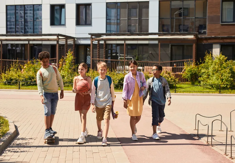 Group of tweens with backpacks walking together after school